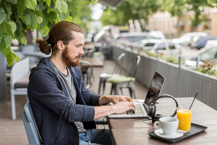 Side view of man at terrace working on laptop